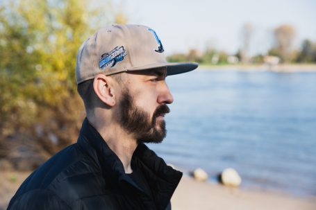 Männerportrait, Mann mit Cap im Herbst, im Hintergrund der Rhein.