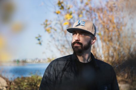 Männerportrait, Mann mit Cap im Herbst, im Hintergrund der Rhein.